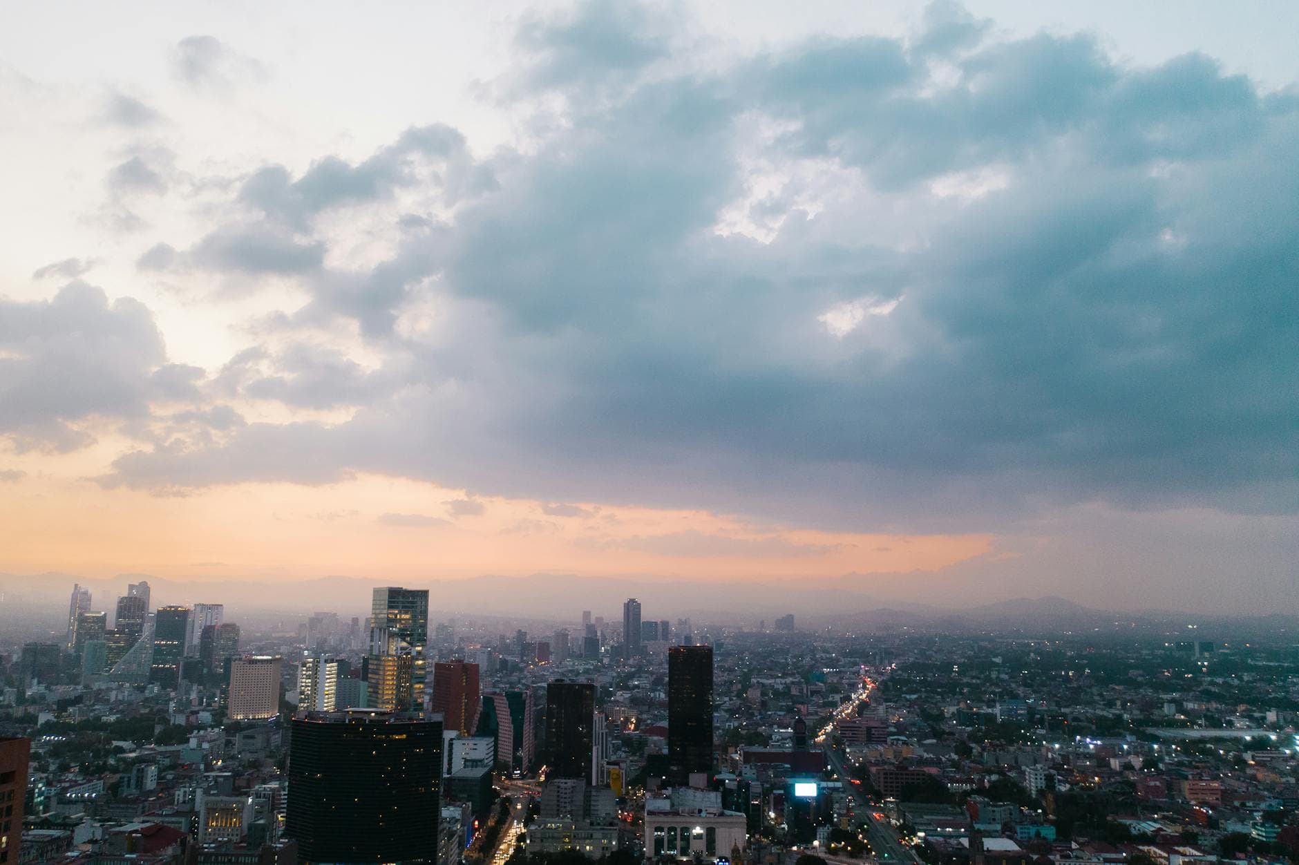 Captivating aerial view of Mexico City skyline at dusk, featuring modern skyscrapers and vibrant urban landscape.