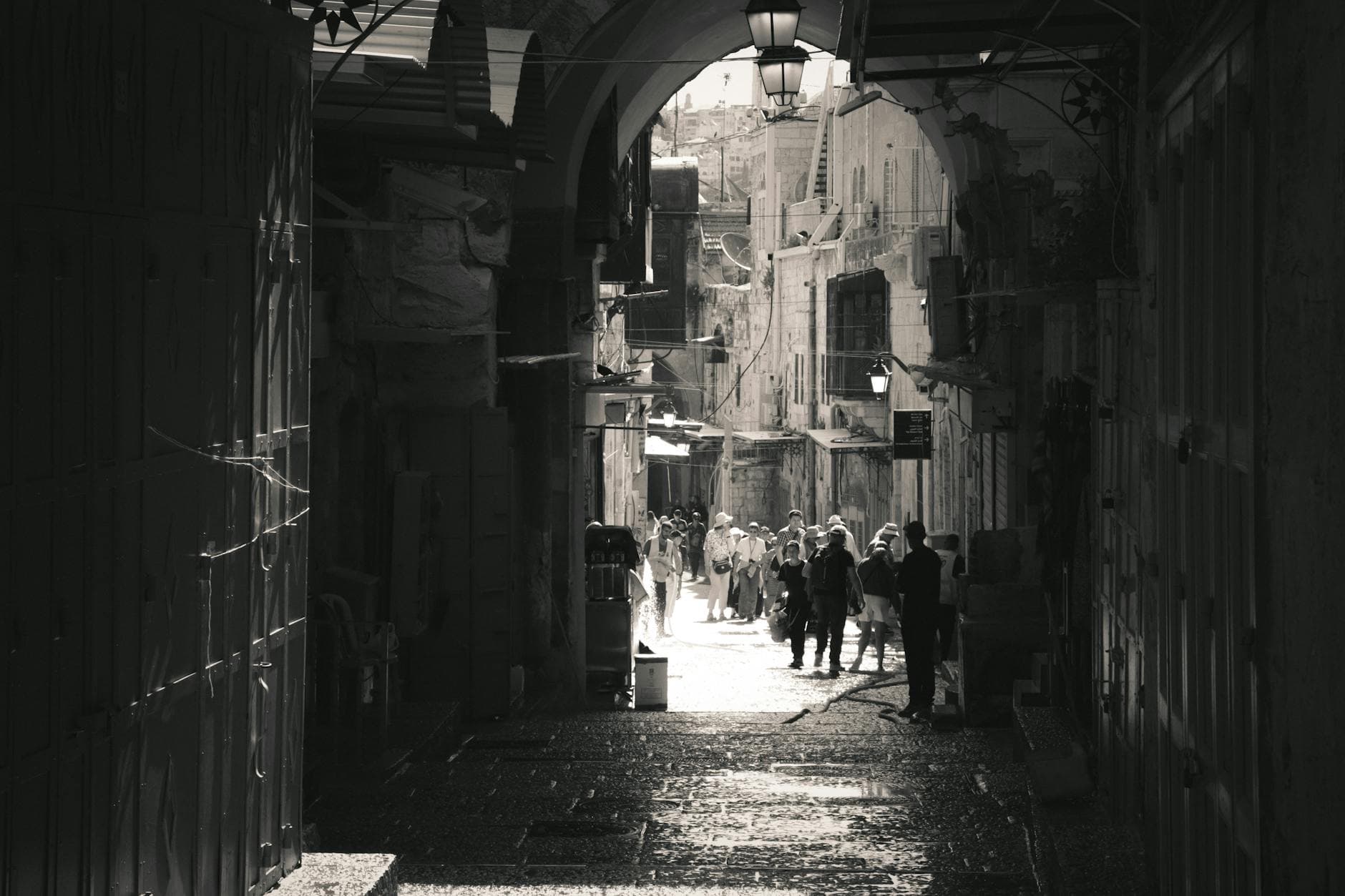 Black and white photo capturing a narrow, bustling street in Jerusalem, Israel.