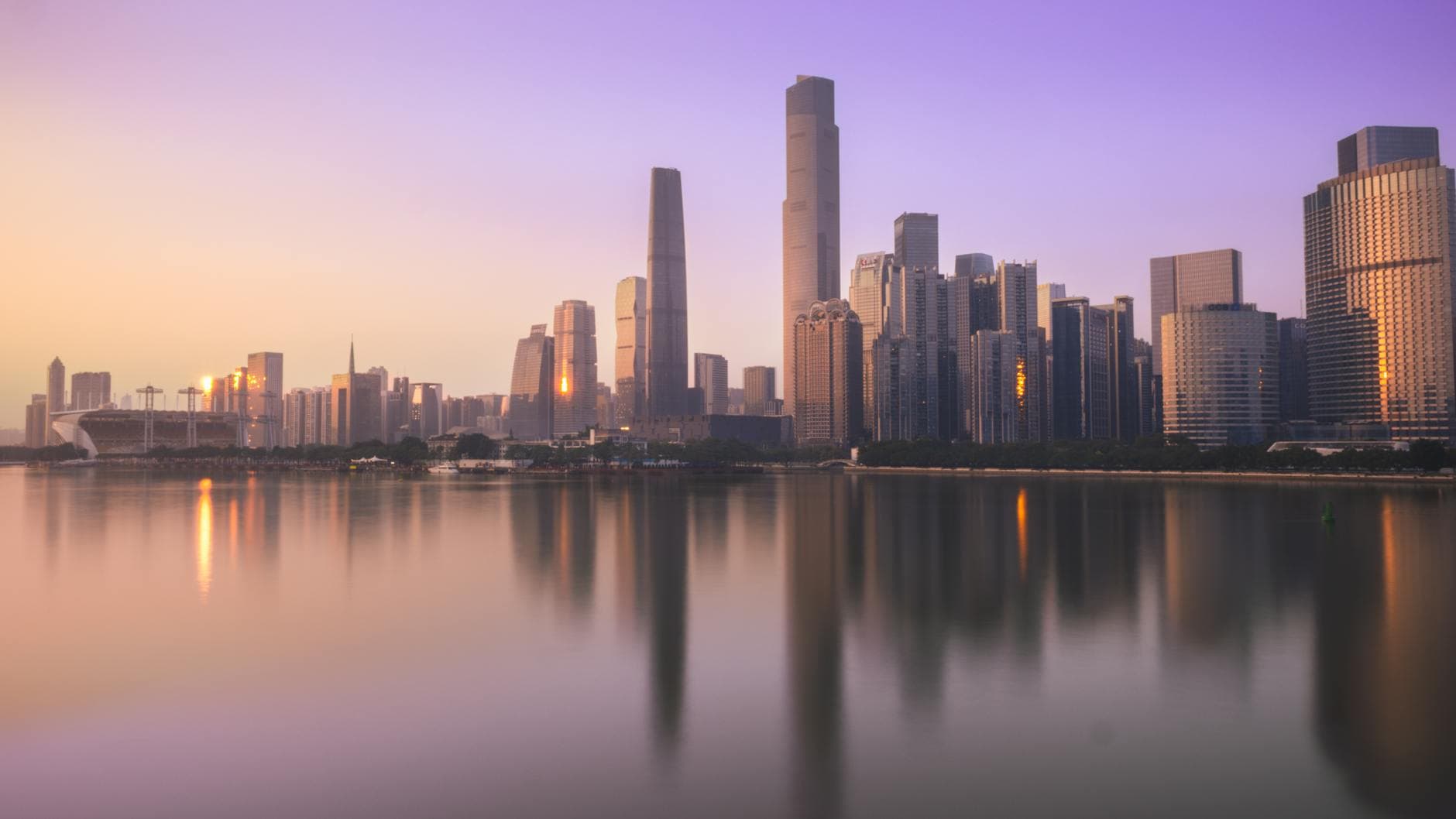 Stunning view of Guangzhou's skyline at sunset, capturing skyscrapers reflecting on the Pearl River.