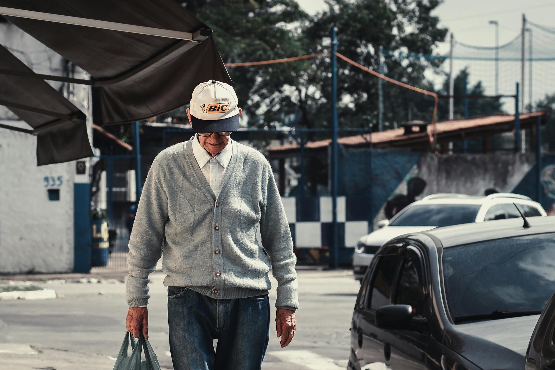 Senior man in casual attire walking along a street in São Paulo, Brazil.