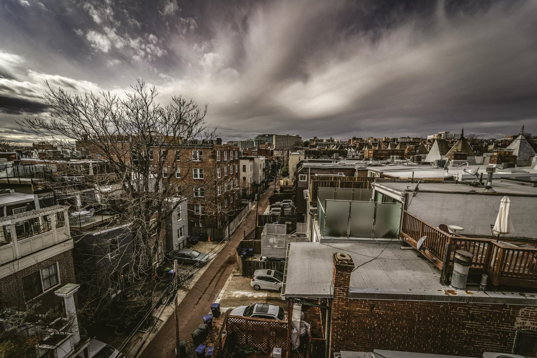 A dramatic aerial view of Washington DC's urban streets and architecture under a cloudy sky.