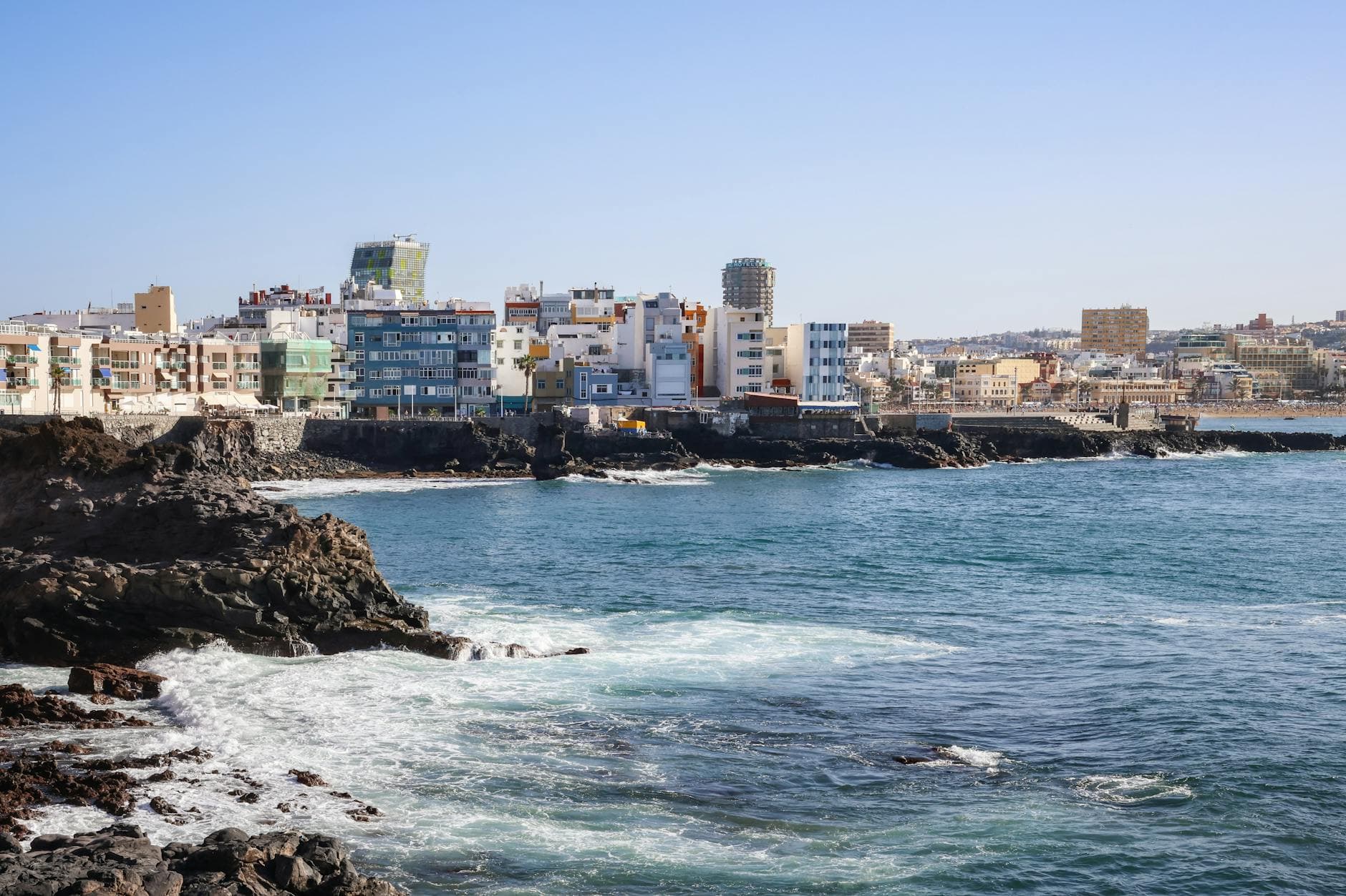 Vibrant cityscape view of Las Palmas de Gran Canaria on a sunny day overlooking the ocean.
